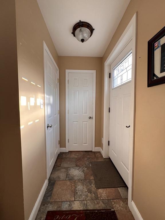 1 Coburn Ct, Lowell, MA 01854 - doorway to outside featuring stone tile flooring and baseboards