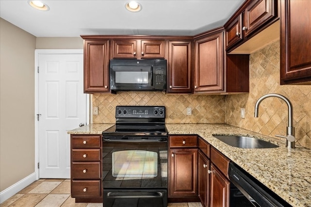 kitchen with light tile patterned floors, sink, light stone counters, black appliances, and decorative backsplash