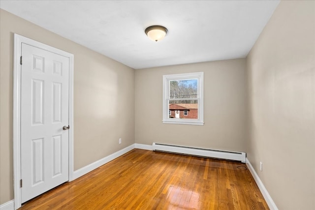 spare room featuring a baseboard radiator and wood-type flooring