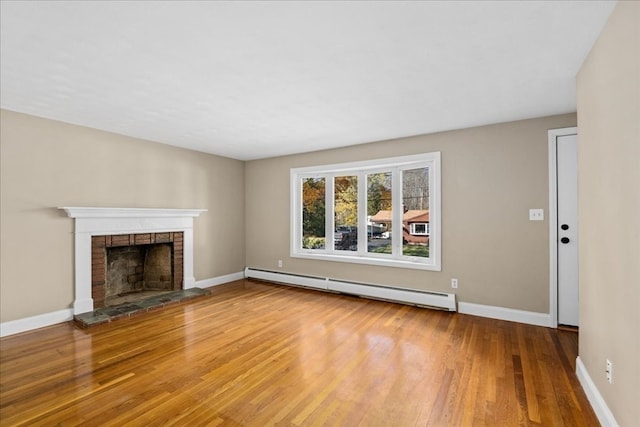 unfurnished living room with a brick fireplace, baseboard heating, and wood-type flooring