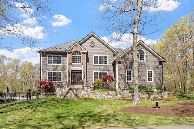 view of front facade featuring fence and a front lawn