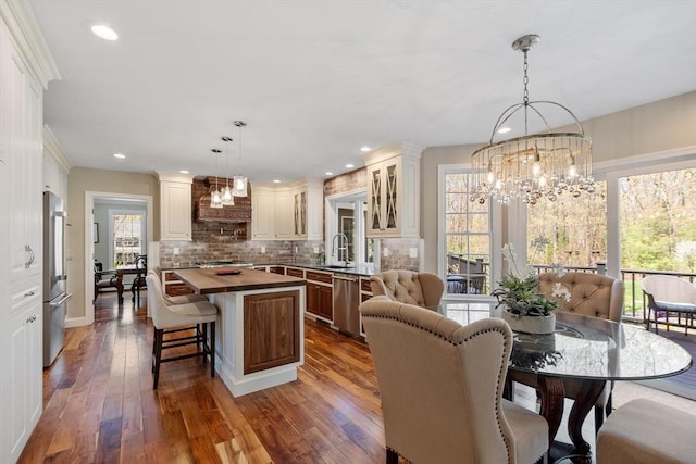 dining space featuring recessed lighting, a notable chandelier, and hardwood / wood-style flooring