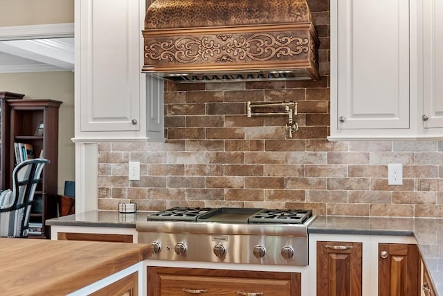 kitchen featuring crown molding, backsplash, white cabinetry, and stainless steel gas stovetop