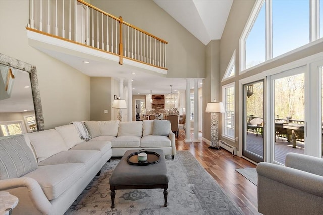 living room with wood finished floors, a healthy amount of sunlight, and high vaulted ceiling