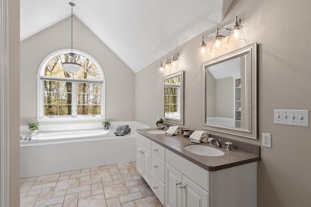 full bathroom with a sink, vaulted ceiling, stone finish flooring, and a bath