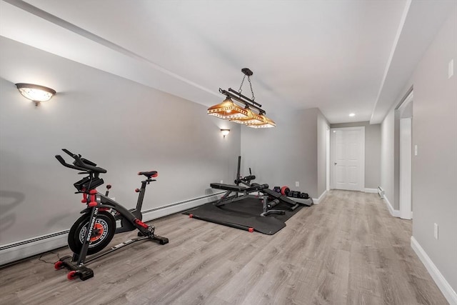 workout area featuring recessed lighting, baseboards, and wood finished floors
