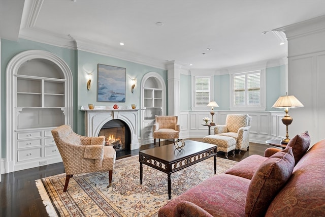 living room with built in features, hardwood / wood-style floors, and crown molding