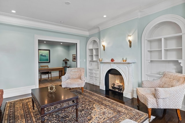 living room with built in features, ornamental molding, and hardwood / wood-style floors