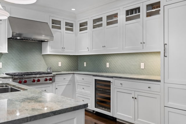 kitchen with tasteful backsplash, beverage cooler, white cabinets, dark hardwood / wood-style floors, and wall chimney exhaust hood