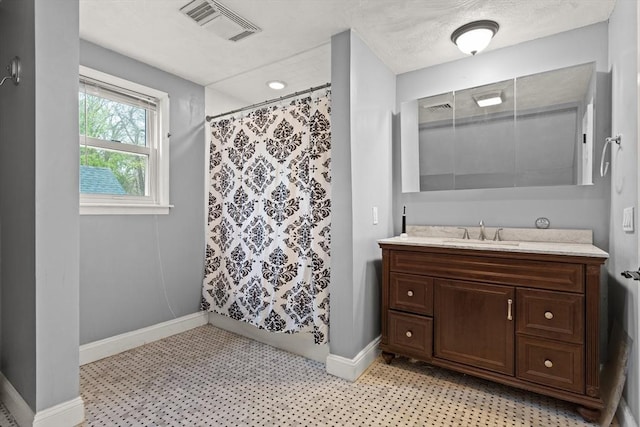 bathroom featuring baseboards, visible vents, a shower with shower curtain, and vanity