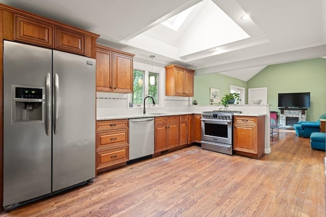kitchen with open floor plan, a peninsula, brown cabinets, and stainless steel appliances