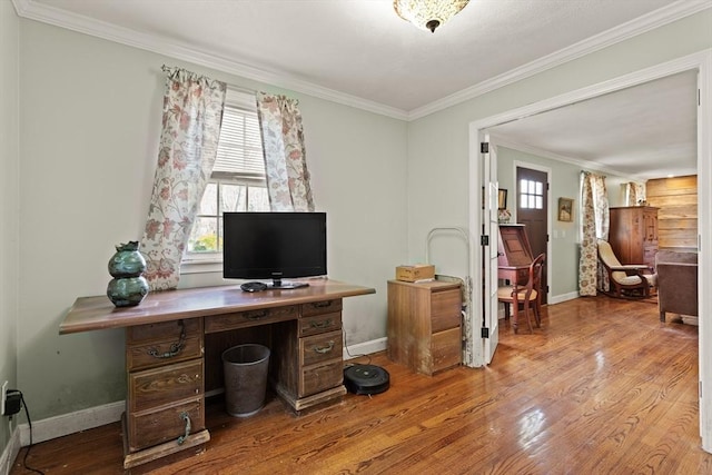 home office featuring crown molding, baseboards, wood finished floors, and a wealth of natural light
