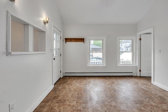 spare room with a baseboard heating unit, baseboards, and stone finish flooring