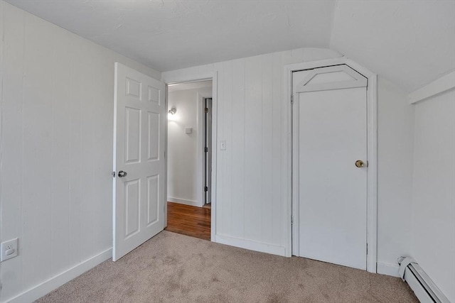 unfurnished bedroom with a baseboard radiator, carpet floors, and vaulted ceiling