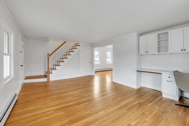 unfurnished living room with baseboard heating, ornamental molding, stairs, light wood-type flooring, and baseboards