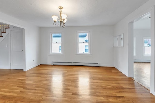 unfurnished dining area featuring a baseboard radiator, a chandelier, stairs, and light wood-style flooring