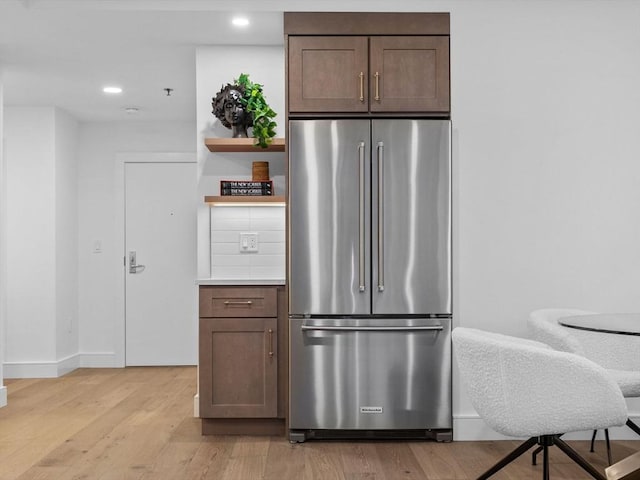 kitchen with high quality fridge, dark brown cabinets, and light wood-type flooring