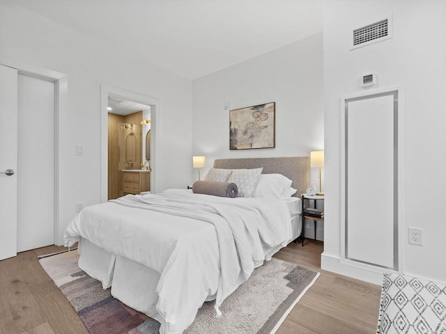 bedroom featuring light hardwood / wood-style floors and connected bathroom