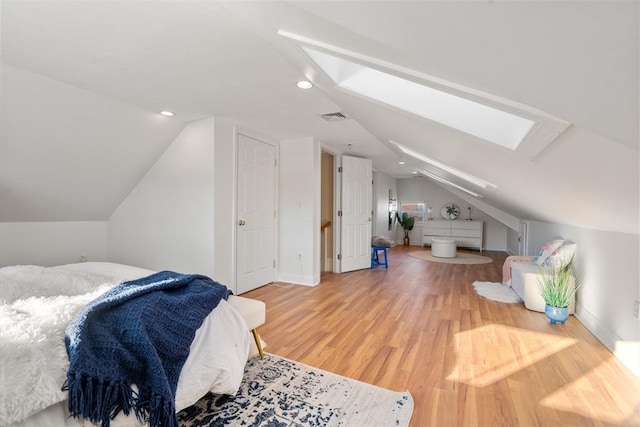 bedroom with wood-type flooring and lofted ceiling with skylight