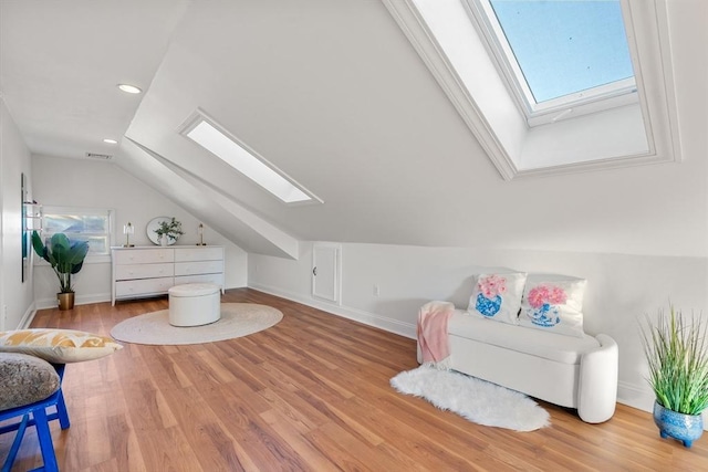 additional living space with a wealth of natural light, lofted ceiling with skylight, and light hardwood / wood-style floors