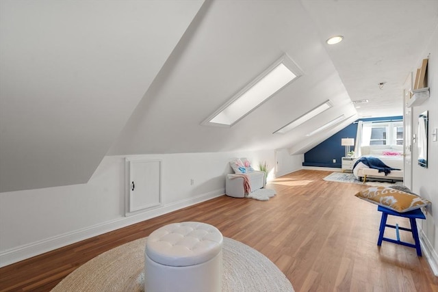 bonus room featuring vaulted ceiling with skylight and light hardwood / wood-style flooring