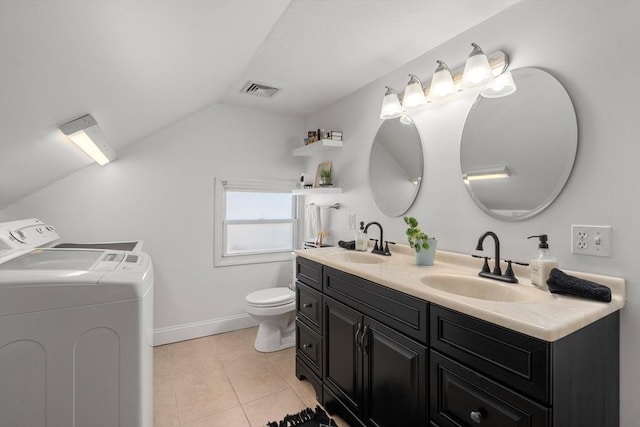 bathroom featuring washing machine and clothes dryer, tile patterned floors, lofted ceiling, toilet, and vanity