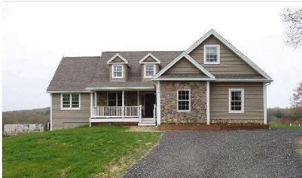 view of front facade featuring covered porch and a front yard