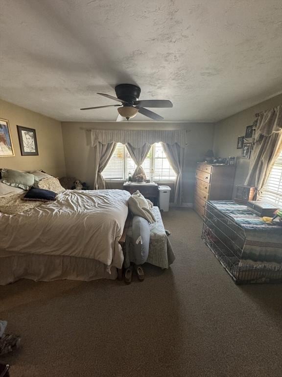 carpeted bedroom featuring a textured ceiling and a ceiling fan