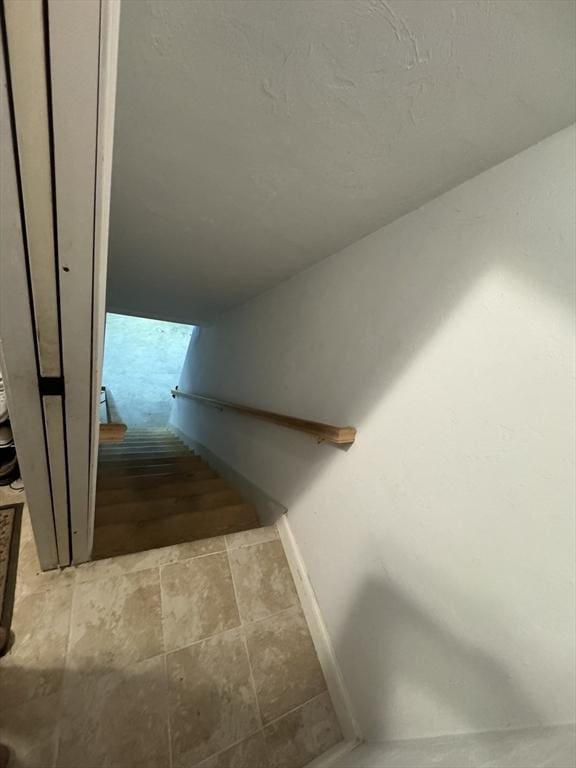 stairs with a textured ceiling and baseboards