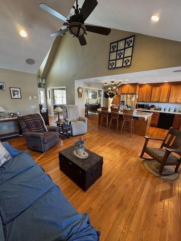 living area with ceiling fan, high vaulted ceiling, light wood-type flooring, and recessed lighting