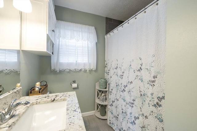 16 Kaveney St, Chicopee, MA 01020 - full bathroom featuring wood finished floors, vanity, a shower with shower curtain, and baseboards