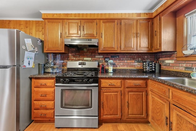 kitchen featuring light hardwood / wood-style floors, stainless steel appliances, backsplash, and crown molding