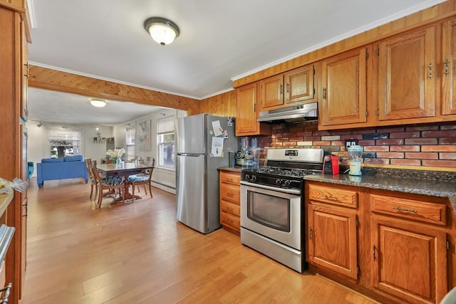 kitchen featuring dark stone countertops, appliances with stainless steel finishes, light hardwood / wood-style flooring, crown molding, and a baseboard radiator