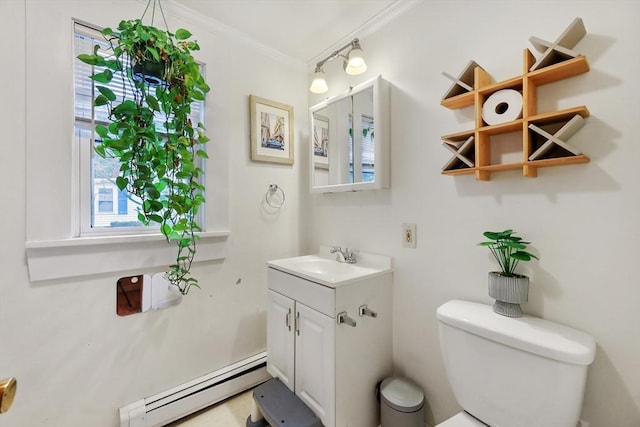 bathroom with toilet, vanity, crown molding, and baseboard heating