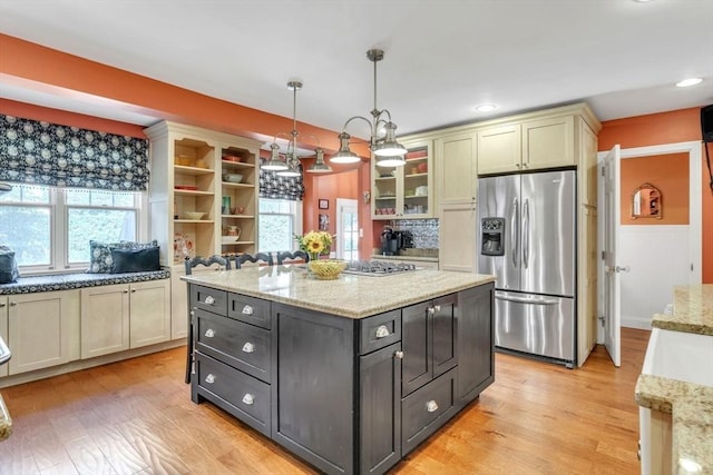 kitchen with a kitchen island, pendant lighting, stainless steel appliances, and light wood-type flooring