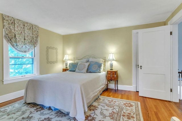 bedroom with baseboards and wood finished floors