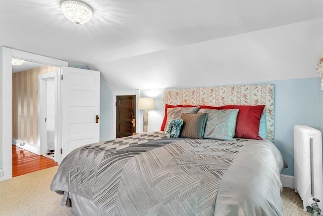 carpeted bedroom featuring vaulted ceiling and radiator heating unit