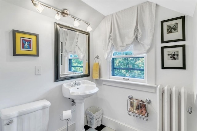 half bathroom with plenty of natural light, toilet, and radiator heating unit