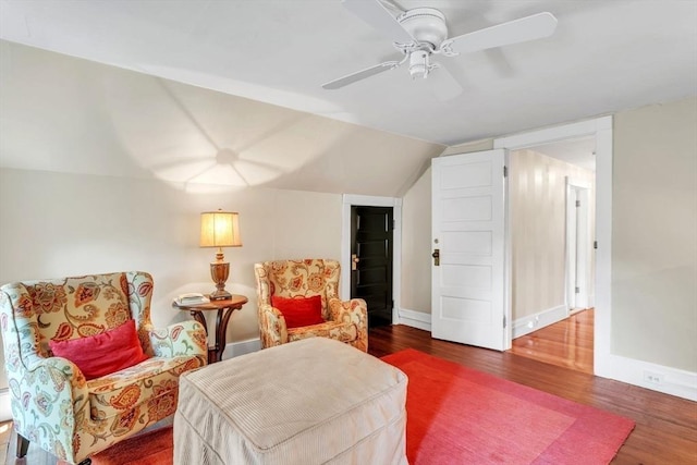 living area with vaulted ceiling, wood finished floors, baseboards, and ceiling fan