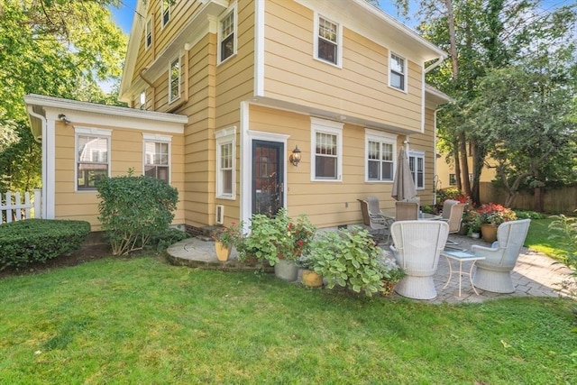 back of house featuring a patio, fence, and a lawn