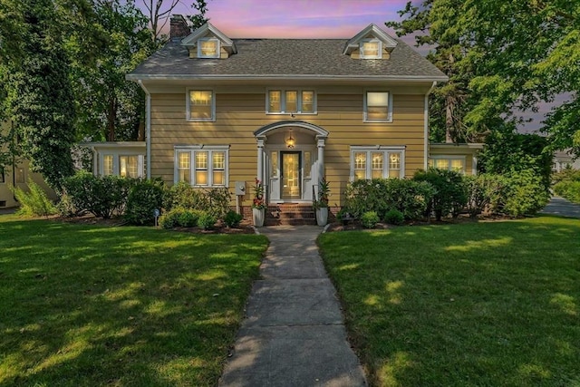 view of front of home with a chimney and a yard