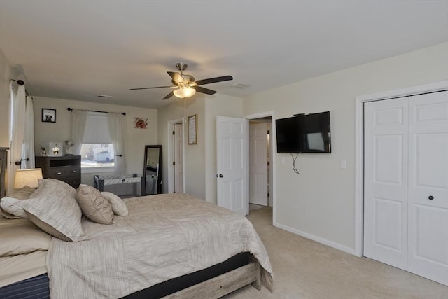 carpeted bedroom featuring ceiling fan and a closet