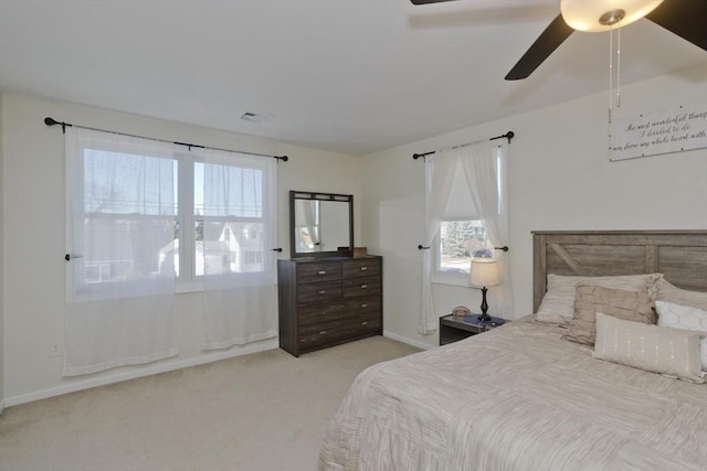 carpeted bedroom featuring multiple windows and ceiling fan