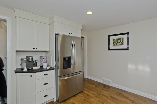 kitchen with white cabinetry, stainless steel fridge with ice dispenser, and light wood-type flooring