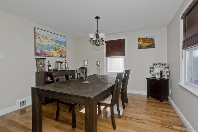 dining area featuring a chandelier and light wood-type flooring