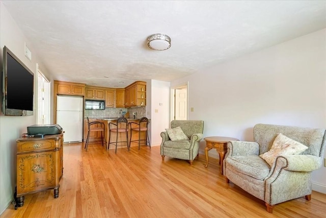 living area featuring light wood-type flooring and baseboards