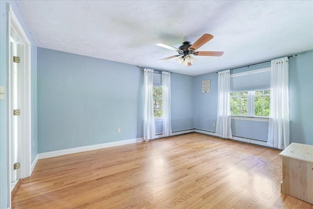 unfurnished room with light wood-style flooring, ceiling fan, and baseboards