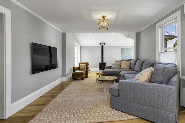 453 Washington St, Gloucester, MA 01930 - living room with wood finished floors, baseboards, a wood stove, crown molding, and a chandelier