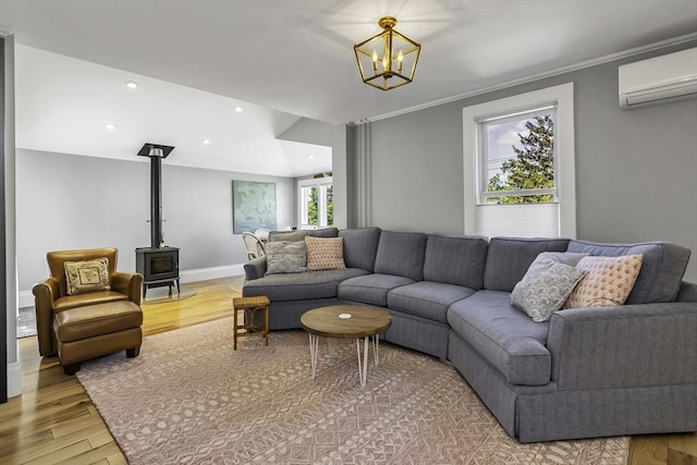 453 Washington St, Gloucester, MA 01930 - living area with an AC wall unit, a wood stove, a chandelier, light wood-style flooring, and recessed lighting