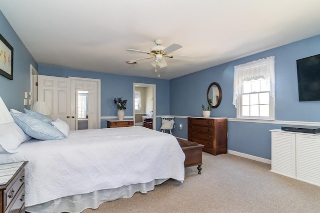 bedroom with connected bathroom, a ceiling fan, baseboards, and carpet